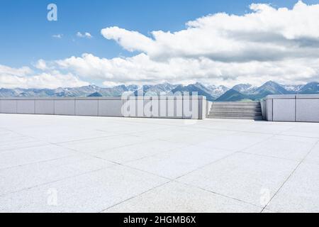 Empty square floor and mountains under blue sky Stock Photo