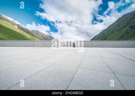 Empty square floor and mountains under blue sky Stock Photo