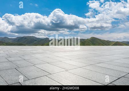 Empty square floor and mountains under blue sky Stock Photo