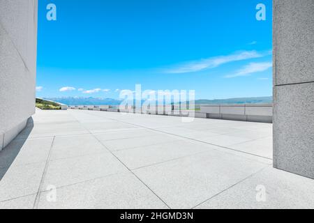 Empty square floor and mountains under blue sky Stock Photo