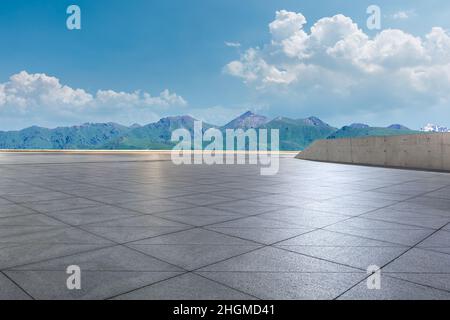 Empty square floor and mountains under blue sky Stock Photo