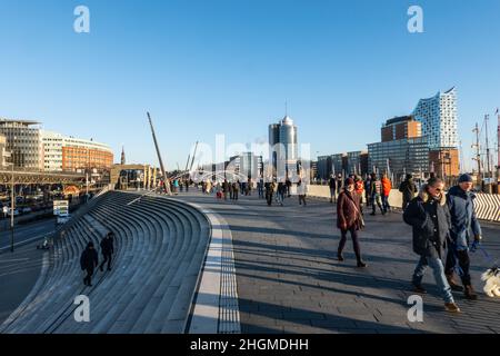 People walking at Hamburg harbour on a sunny day - CITY OF HAMBURG, GERMANY - DECEMBER 21, 2021 Stock Photo