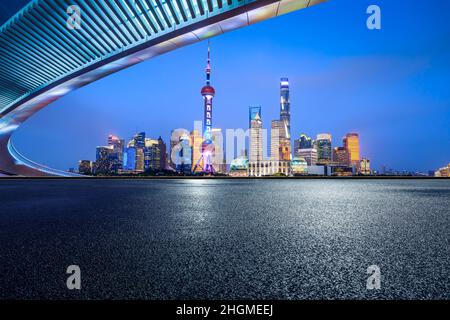 Panoramic skyline and modern commercial buildings with empty road. Asphalt road and cityscape at night. Stock Photo