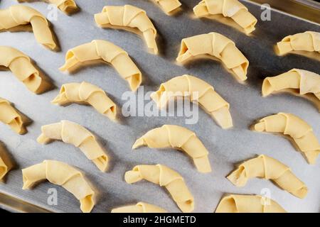 Baking pan with raw crescent cookies on wooden table. Top view. Stock Photo