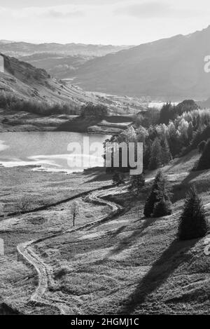 Black and white Stunning vibrant Autumn landscape image looking from Pike O'Blisco towards Blea Tarn with beautiful sungiht on mountains and valley Stock Photo