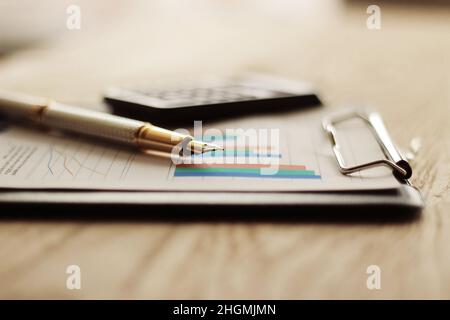 pen, calculator and financial graph on a workplace Stock Photo