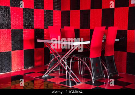 Table and chairs in red and black space Stock Photo