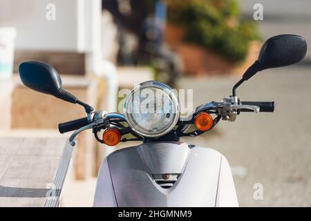A vintage  pink   motorcycle, moped  stands in a parking against the backdrop of  street,  front  view Stock Photo
