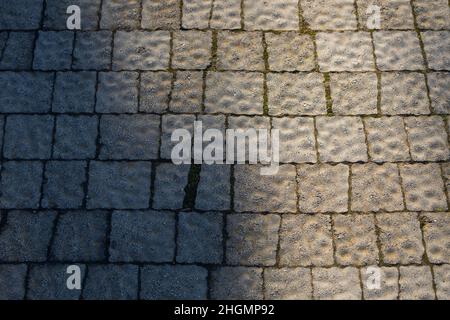 Close-up of a street gray polygonal tile with raised details. Tile pattern Stock Photo