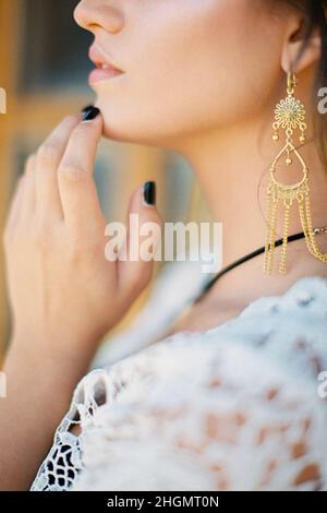 Young woman touches her chin with her fingers. Close-up Stock Photo