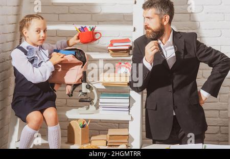 Father explaining homework to his daughter at home. Doing homework with dad. Stock Photo