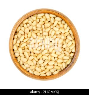 Cedar nuts, pine nuts, harvested in Russia, in a wooden bowl. Edible seeds of Siberian pine, Pinus sibirica, also called pinon, pinoli and pignoli. Stock Photo