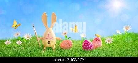Easter bunny with a paintbrush on a sunny lawn. Flower meadow with Easter eggs. Easter card. 3 d render Stock Photo