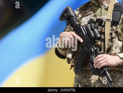 Soldier of Ukraine with assault rifle and flag of Ukraine on military ...