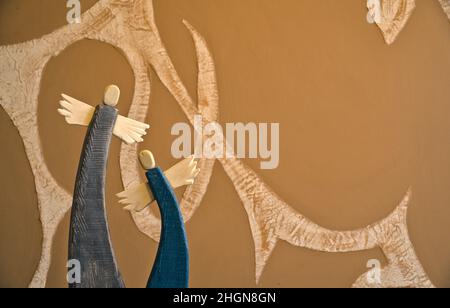 wooden painted angels on abstract blurry background with winding motif Stock Photo