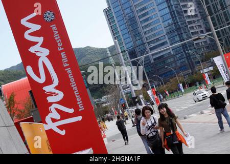 October 4, 2012 - Busan, South Korea : Visitors pass past walk by placard during the 17th Busan International Film Festival opening ceremony at the Busan Cinema Center. Along with the now inevitable galaxy of stars promoting blockbusters from across Asia, this year's Busan International Film Festival will screen a North Korean film for the first time in almost a decade as well as six classic Afghan movies that were hidden in a wall to save them from the Taliban. (Ryu Seung-il / Polaris) Stock Photo