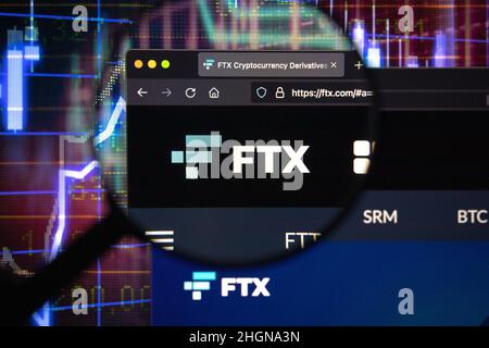 FTX crypto company logo on a website, seen on a computer screen through a magnifying glass. Stock Photo