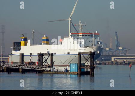 The Ro-Ro cargo ship ,Celestine' on the river Thames leaving London docks. Passing Tilbury docks and a wind turbine in the background. Stock Photo