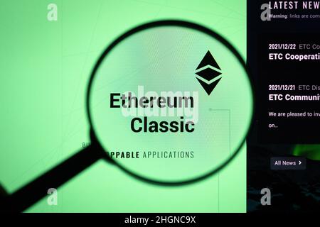 Ethereum Classic crypto company logo on a website, seen on a computer screen through a magnifying glass. Stock Photo