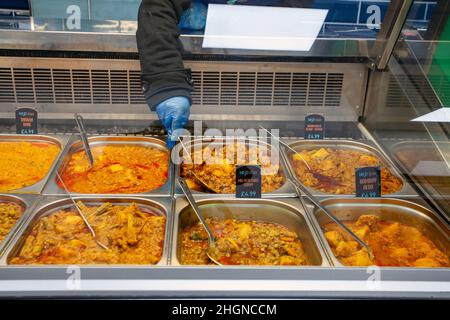 Hot spicy Indian cooked foods on display in popular Preston city centre Heat & Eat take-away. Achari Murgh a north Indian curry made with pickling spices and chicken, Chicken Korma, Chicken Balti, Pumpkin curry. All for sale to discerning diners Stock Photo