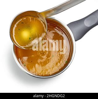 fresh chicken broth pouring into saucepan isolated on white background, top view, selective focus Stock Photo