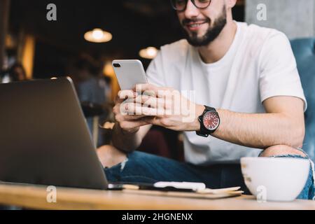 Cropped image of male programmer using cellphone technology for checking mobility notification Stock Photo