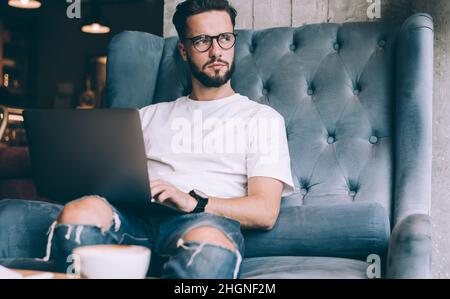 skilled blogger man with netbook thinking indoors Stock Photo