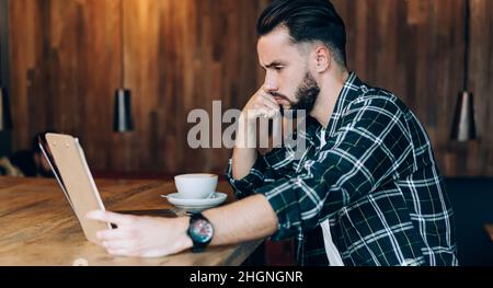 confused copywriter checking text notes during freelance remote working with laptop computer Stock Photo