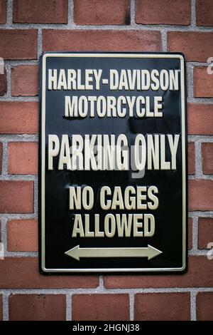 harley davidson parking only sign on brick wall Stock Photo