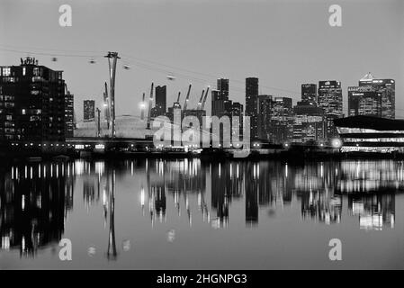 Canary Wharf, Emirates Cable Car Crossing and the O2 Arena, illuminated at dusk, viewed from Royal Victoria Dock in London's Docklands, East London UK Stock Photo