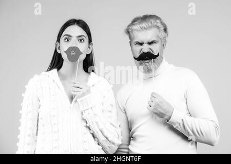 Photo booth concept. Couple having fun with with fake mustache and lips. Stock Photo