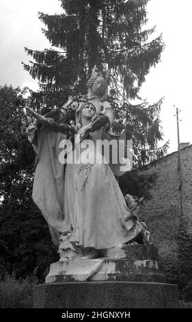 1950s, historical, A statue in front of La Maison Natale de Jeanne d'Arc, a two-storey stone farm building, with sloping roof, where Joan of Arc was born in the 15th century, Domremy-la-Pucelle, France.  Her birth house in Domrémy was preserved and became a museum. Also known as the 'The Maid of Orleans' this simple peasant girl is considered a national heroine in French culture, as believing that she was acting under the will of god, she led the French army to victory at Orleans in 1429 against the English during the Hundred Years War. Stock Photo