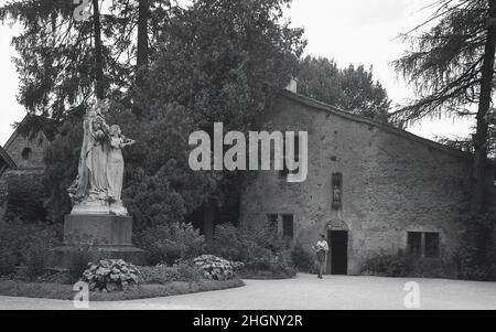 1950s, historical, exterior view from this era of La Maison Natale de Jeanne d'Arc, a two-storey stone farm building, with sloping roof, where Joan of Arc was born in the 15th century, Domremy-la-Pucelle, France. A statue stands in front of the house. Her birth house in Domrémy was preserved and became a museum. Also known as the 'The Maid of Orleans' this simple peasant girl is considered a national heroine in French culture, as believing that she was acting under the will of god, she led the French army to victory at Orleans in 1429 against the English during the Hundred Years War. Stock Photo