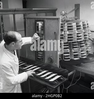 1950s, historical, Leeds Unversity, a male research scientist in a white-coat with table-top electronic machine that is printing data on cards. Words on dial, Hohe in tvm suggest a German made piece of equipment. By this era it developed a strong tradition of research. Founded in 1904,  University's origins go back to the 19th century with the Leeds School of Medicine in 1831 and the Yorkshire College of Science in 1874. Stock Photo