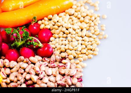 vegan food: pinto beans, radishes, carrots, and soy with copy space Stock Photo