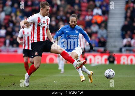 Sunderland's Callum Doyle (left) and Portsmouth's Marcus Harness battle for the ball during the Sky Bet League One match at the Stadium of Light, Sunderland. Picture date: Saturday January 22, 2022. Stock Photo