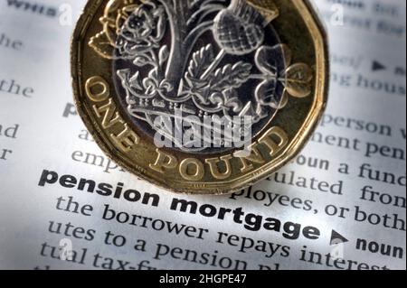 DICTIONARY DEFINITION OF WORDS PENSION MORTGAGE WITH ONE POUND COIN RE PENSIONS RETIREMENT COST OF LIVING RISING PRICES SAVINGS PENSIONERS ETC UK Stock Photo