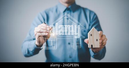 engineering and architecture drawings concept, Engineer man hold house on virtual screen of architect ,Insurance agent with model of house on light ba Stock Photo