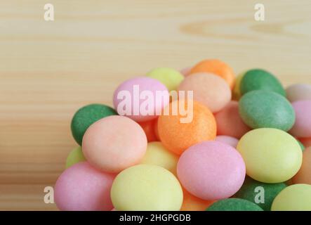 Pile of Beautiful Pastel Colored Sugar Coated Candies on Wooden Backdrop Stock Photo