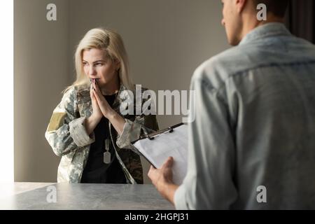 Military woman. Blonde experienced military woman suffering from insomnia coming to psychologist. Stock Photo