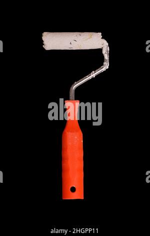 paint roller with red handle in white paint isolated on a black background Stock Photo