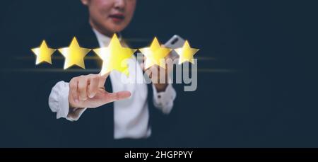 The concept of placing rating. woman touching technology on five star excellent rating on blue background, Concept of satisfaction, quality and perfor Stock Photo