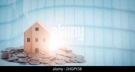 Coins stack in front of wooden home and arrow business, Save money concept, Property investment, house loan, reverse mortgage, gold coins money stack Stock Photo