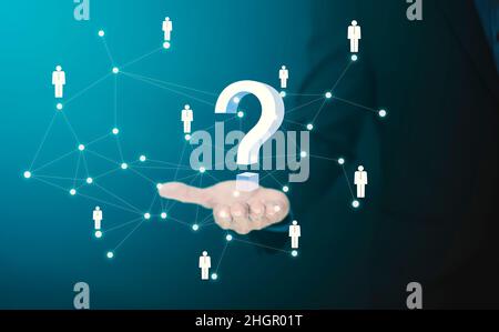 Businessman hand hold interface question marks sign web with line people, Question marks drawn on black background. Concept of searching for an answer Stock Photo