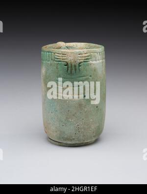Jar with decorated rim, swivel, and knob 664–30 B.C. Late Period–Ptolemaic Period The color of this cylindrical vessel suggests a Late Period or Ptolemaic Period date, although the type of the vessel seems unfamiliar in Egypt. In a thickening on one side of the vessel's lip there is a hole for a swivel for the now missing lid. When meant to remain closed, string would have secured a knob on the lid to a knob protruding from the side of the vessel opposite the swivel.. Jar with decorated rim, swivel, and knob. 664–30 B.C.. Faience. Late Period–Ptolemaic Period. From Egypt Stock Photo