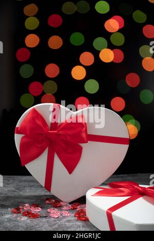 heart shaped gift box on a black background with coloured bokeh Stock Photo