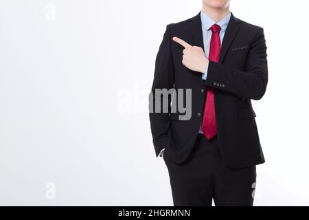 Businessman in black suit pointing by finger isolated on white background. Copy space and mock up. Business concept. Cropped image Stock Photo