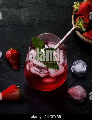 Fresh strawberry cocktail. Fresh summer cocktail with strawberry and ice cubes. Glass of strawberry soda drink on dark background Stock Photo