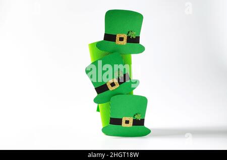 Creative background on St. Patrick's Day on March 17. Lepricon's paper hats on a corrugated decorative tube Stock Photo