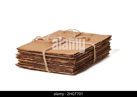 Tied pile of corrugated fiberboard ready for recycling isolated on a white background. Waste paper Stock Photo